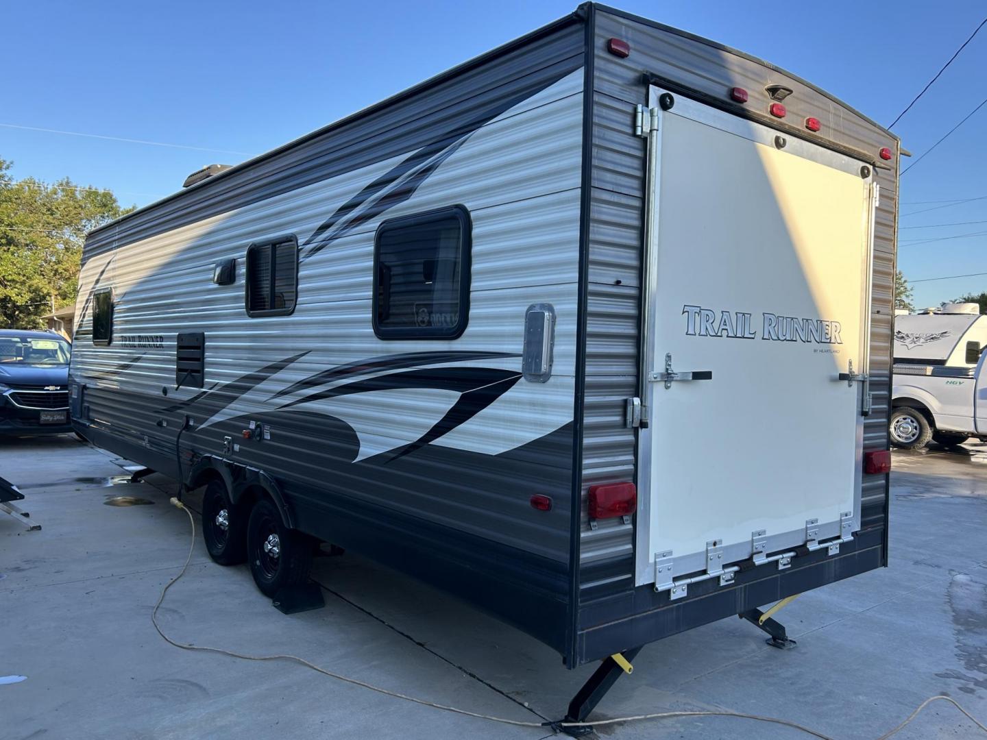 2017 White /TAN HEARTLAND TRAIL RUNNER TOY HAULER 26TH (5SFEB3027HE) , located at 17760 Hwy 62, Morris, OK, 74445, 35.609104, -95.877060 - WE HAVE THE PERFECT CAMPER FOR YOU TO CAMP AND HAUL YOUR TOYS IN. THIS IS A 2017 HEARTLAND TRAIL RUNNER OVERALL 30FT. IT FEATURES 17FT POWER AWNING, POWER JACK STABILIZERS, AMFM BLUETOOTH RADIO. IN THE FRONT YOU HAVE A QUEEN SIZED BED WITH STORAGE UNDERNEATH, OVERHEAD STORAGE, 2 WARDROBE CLOSETS, CO - Photo#4